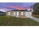 Beautiful single-story home with a gray exterior, a white garage door, and a freshly landscaped yard at 15390 Sw 10 Pl, Ocala, FL 34481