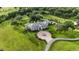 Aerial view of a luxurious two-story home with a circular driveway and fountain at 22422 Lake Seneca Rd, Eustis, FL 32736