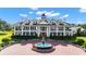 Exterior view of a grand two-story home with a fountain and circular driveway at 22422 Lake Seneca Rd, Eustis, FL 32736