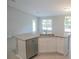 Modern kitchen island with a double sink, dishwasher, and white shaker cabinets at 4473 Nw 48Th Ln, Ocala, FL 34474