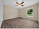 Bright bedroom featuring wood-look flooring, a ceiling fan, and a view to the backyard at 706 Stanley Ave, Wildwood, FL 34785