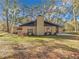 Rear view of a ranch house with metal roof, chimney, and landscaping at 7131 Sw 19Th Avenue Road Rd, Ocala, FL 34476