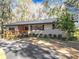 Front view of a ranch house with metal roof, landscaping, and driveway at 7131 Sw 19Th Avenue Road Rd, Ocala, FL 34476