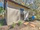 Gray storage shed with black door and landscaping at 7131 Sw 19Th Avenue Road Rd, Ocala, FL 34476