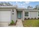 Charming single-story home with a well-maintained lawn and a bright, inviting turquoise front door at 7336 Sw 131St Ln, Ocala, FL 34473