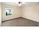Cozy bedroom with plush carpeting, ceiling fan, and a large window offering a pleasant view at 4937 Nw 30Th Pl, Ocala, FL 34482
