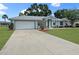 Charming single-story home with a well-maintained lawn and a spacious driveway leading to a two-car garage at 4937 Nw 30Th Pl, Ocala, FL 34482