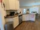 A kitchen area showcases white cabinets, a stainless steel dishwasher, and sleek countertops at 9029 Se 47Th Court Rd, Ocala, FL 34480