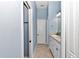 Hallway features a vanity with a sink and a mirror with accent lighting at 6925 Se 96Th Place Rd, Belleview, FL 34420