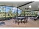 Spacious screened patio featuring a dining set, lounge chairs, and lovely backyard views at 6925 Se 96Th Place Rd, Belleview, FL 34420