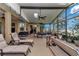 Relaxing screened patio with lounge chairs, dining table, and lush green plants at 6925 Se 96Th Place Rd, Belleview, FL 34420