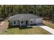 Charming single-story home with gray exterior, attached garage, and manicured front yard landscaping at 11404 Sw 131St Ter, Dunnellon, FL 34432