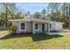 Attractive single-story home with a gray exterior, a well-kept lawn, and tasteful front yard landscaping at 11404 Sw 131St Ter, Dunnellon, FL 34432