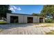 Exterior shot of metal outbuilding with multiple garage doors and gravel parking at 17800 Se 237Th Ct, Umatilla, FL 32784