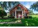 Charming brick house with a manicured lawn, mature trees, and a welcoming front porch at 17800 Se 237Th Ct, Umatilla, FL 32784