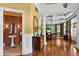Elegant foyer featuring hardwood floors, detailed columns, and a view into a stylishly tiled powder room at 17800 Se 237Th Ct, Umatilla, FL 32784
