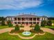 Elegant brick home with symmetrical landscaping, fountain, and covered balcony at 17800 Se 237Th Ct, Umatilla, FL 32784