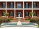 Close-up of a fountain and grand front facade with pillars and a covered balcony at 17800 Se 237Th Ct, Umatilla, FL 32784