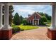 Beautiful brick home with manicured lawn, decorative shrubs, and a circular driveway at 17800 Se 237Th Ct, Umatilla, FL 32784