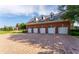 Four-car garage with dormer windows above and a brick paved drive at 17800 Se 237Th Ct, Umatilla, FL 32784