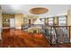 Elegant hallway featuring a decorative railing, hardwood floors, and stunning chandelier at 17800 Se 237Th Ct, Umatilla, FL 32784