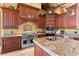 Gourmet kitchen with custom cabinets, granite countertops, and stainless steel appliances at 17800 Se 237Th Ct, Umatilla, FL 32784