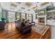 Cozy living room with a fireplace, plush leather seating, and elegant chandelier at 17800 Se 237Th Ct, Umatilla, FL 32784