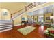 Open-concept living area with a staircase, wood floors, and a view to the dining area at 17800 Se 237Th Ct, Umatilla, FL 32784