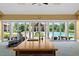 Pool house featuring folding glass doors, a sink area, and a view of the pool and landscaped grounds at 17800 Se 237Th Ct, Umatilla, FL 32784