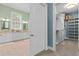 View into walk-in closet, with custom shelving and storage options, attached to a modern bathroom at 17800 Se 237Th Ct, Umatilla, FL 32784
