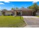 Single-story house with a brown garage door and stone accents at 21406 Sw Plantation St, Dunnellon, FL 34431