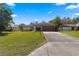 House exterior showcasing a large yard and driveway at 21406 Sw Plantation St, Dunnellon, FL 34431