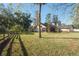 A home with a sprawling backyard bordered by a wooden fence and mature trees at 4215 Se 24Th Ter, Ocala, FL 34480