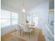 Sunlit dining area boasts a modern table, sleek white chairs, and views of the backyard at 4215 Se 24Th Ter, Ocala, FL 34480