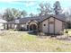 Single-story home with well-maintained lawn, mature trees, and an arched entryway at 4215 Se 24Th Ter, Ocala, FL 34480