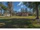 Expansive front lawn of a single-story home, framed by mature trees, offering a serene and inviting curb appeal at 4215 Se 24Th Ter, Ocala, FL 34480