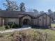 Inviting single-story home featuring a well-manicured lawn, arched entryway, and attractive landscaping at 4215 Se 24Th Ter, Ocala, FL 34480