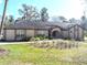 Lovely single-story home with an arched entryway, manicured lawn, and mature landscaping at 4215 Se 24Th Ter, Ocala, FL 34480