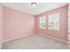 Light pink bedroom with two windows, carpet, and a closet at 4737 Se 36Th St, Ocala, FL 34480