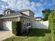 Side view of a two-story house, with grass, a fence, and garage at 3403 Gatlin Place Cir, Orlando, FL 32812
