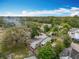Aerial view of a single-Gathering home nestled among mature trees with a spacious yard under a partly cloudy sky at 34828 1St Ave, Leesburg, FL 34788