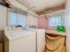 Bright laundry room featuring washer, dryer, and folding counter at 34828 1St Ave, Leesburg, FL 34788