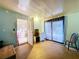 View of the living room area including an exterior exit door, large window, and view into an adjacent bedroom at 34828 1St Ave, Leesburg, FL 34788