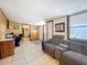 Spacious living room with gray sofa, wood paneling, and tile floors at 34828 1St Ave, Leesburg, FL 34788