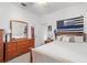 Bright bedroom featuring a full-size bed, wooden dresser, and ceiling fan at 4893 Sw 4Th Cir, Ocala, FL 34471
