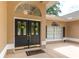 Close up of the front door with beautiful wreaths, elegant hardware, and transom window at 4893 Sw 4Th Cir, Ocala, FL 34471