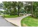 Inviting single-story home featuring a concrete driveway and lush landscaping with mature trees at 4893 Sw 4Th Cir, Ocala, FL 34471