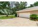 Attached garage with basketball hoop surrounded by manicured landscaping and concrete driveway at 4893 Sw 4Th Cir, Ocala, FL 34471