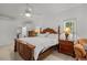 Bright main bedroom with a ceiling fan, tile flooring, and a stately, carved wooden bed at 4893 Sw 4Th Cir, Ocala, FL 34471