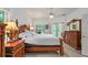 Main bedroom featuring elegant wood furniture, a ceiling fan, and sliding doors to the pool area at 4893 Sw 4Th Cir, Ocala, FL 34471